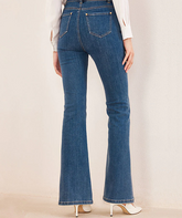 the back view of a lady in blue denim flared jeans